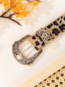 Close-up of leopard print belt with golden rivet trim and vintage carved metal buckle