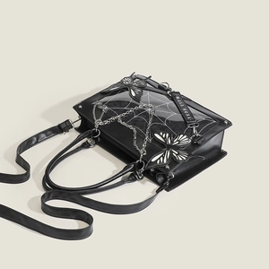 Detail of gothic black tote bag with butterfly appliques and silver chain accents