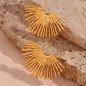 Detailed view of sunburst fan-shaped earrings in 18K gold plating on stone texture