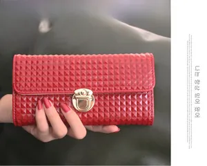 Gros plan d'une pochette rouge avec motif en diamant et fermoir métallique doré chic