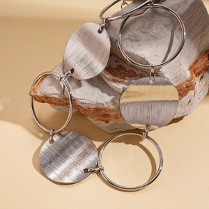 Macro detail of metallic textured rings and dual-tone discs on a natural stone surface