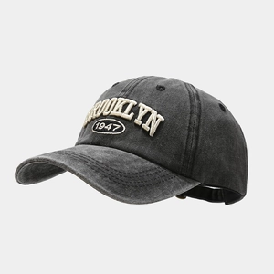 Detail of vintage washed denim baseball cap with 3D Brooklyn 1947 embroidery in dark grey