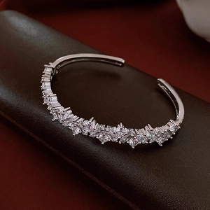 Close-up of irregular silver open cuff bracelet with multifaceted white cubic zirconia