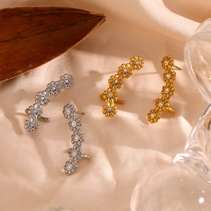 Vintage 18K gold and silver stainless steel daisy zircon ear cuffs on silk background