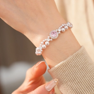 Elegante bracciale a doppia fila di perle con gemma rosa tonda e dettagli in zircone