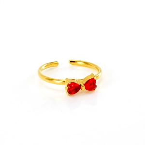 Macro view of gold bow ring featuring two red heart-shaped gems and open band detail