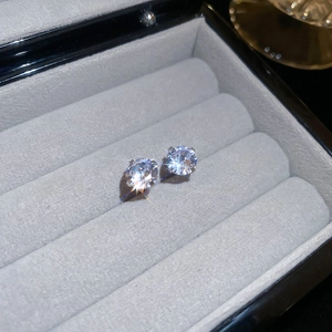 Macro shot of silver stud earrings with sparkling round zircon in a four-prong setting
