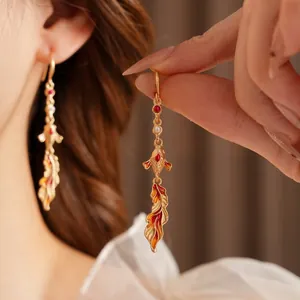 Vintage koi fish drop earrings with red enamel and gold-plated pearls on female model