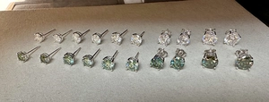 Detailed size comparison of classic four-prong moissanite stud earrings in white and green