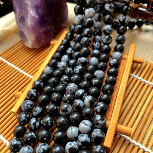 Macro view of natural snowflake jasper loose beads with black and white spotted texture