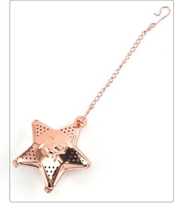 Macro detail of rose gold star-shaped tea infuser with fine mesh and smiley face design