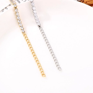 Detail of gold and silver dainty chains with round-cut zircon stones and extenders
