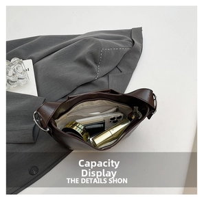 Detail showing the spacious interior of the brown tote bag with phone and cosmetics