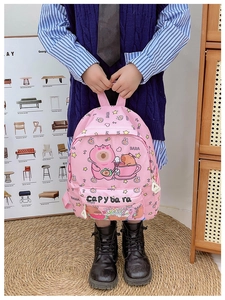 Girl wearing pink Capybara backpack with Don't Worry Be Happy slogan and cute cartoon prints