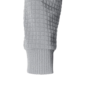 Detail des grauen Waffelstrickstoffs und der Rippbündchen an einem Herren-Kapuzenpullover