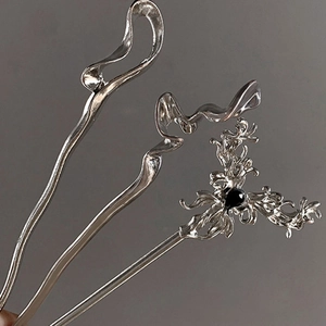 Detail of silver hairpins with liquid metal design and black teardrop gemstone accent
