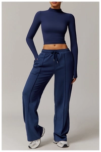 Detail of dark blue high-neck long sleeve workout top and wide-leg yoga pants
