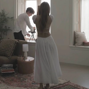 Elegant white backless maxi dress with puff sleeves and tie design shown in a photo studio