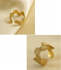 Detail of 18K gold plated gear-shaped stainless steel open ring on satin fabric