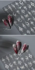 Macro detail of gothic nail stickers with silver laser crosses and thorn patterns