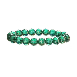 Macro shot of dark green faceted crystal beads showing light refraction and texture