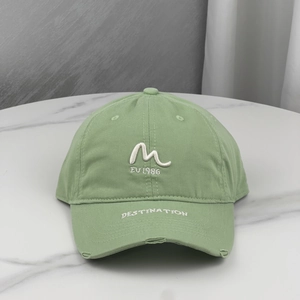 Detail of embroidered letters and distressed ripped brim on the cotton baseball cap