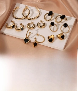 Macro shot of 10 pairs of vintage gold titanium steel earrings with black zircon stones