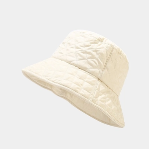 Detail view of cream white quilted bucket hat featuring diamond lattice pattern texture