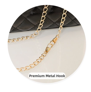 Detail of quality gold metal clasp and chain on black quilted texture shoulder bag