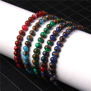 Detail of 6mm natural agate beaded bracelets in multiple colors on a white display stand