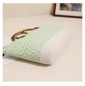 Close-up of woven tote bag with green and white patterns and authentic bamboo handle