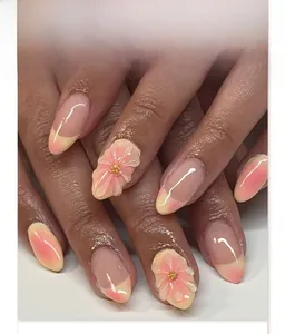 Macro shot of 3D embossed pink flower detail on yellow gradient press-on nails