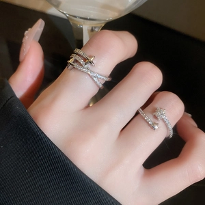 Detailed view of silver star rings with sparkling zircon inlay on woman's hand