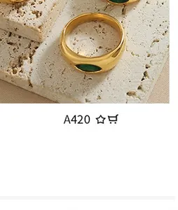 Detailed close-up of a chunky gold-plated ring featuring an oval green stone inlay
