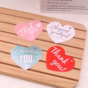 Macro shot of colorful heart-shaped paper gift tags with printed Thank You greetings