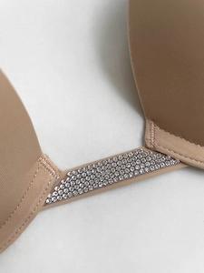 Close-up of sparkling silver rhinestones on a beige push-up bra with smooth stitching