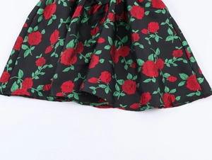 Gros plan détaillé sur tissu jacquard noir avec motifs de roses rouges et feuilles