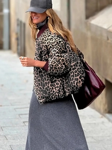 Detail of short leopard print puffer jacket with dark red ribbed cuffs and collar trim