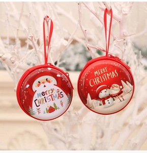 Close-up of round Christmas coin purses with Santa and Snowman hanging on branches