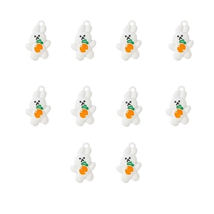 Close-up of ten white rabbit charms with orange carrots and metal loops for DIY jewelry