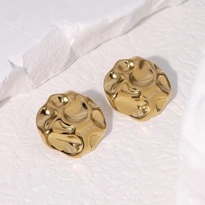 Minimalist irregular hammered gold stainless steel stud earrings on a stone background