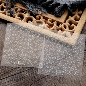 Close-up of heart-shaped hollow nail stickers in gold and silver finish models TH-1016 and 1017
