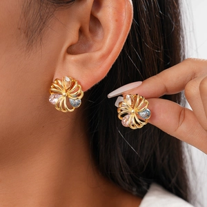 Macro detail of 18K gold-plated floral stud earrings with colorful zircon crystals
