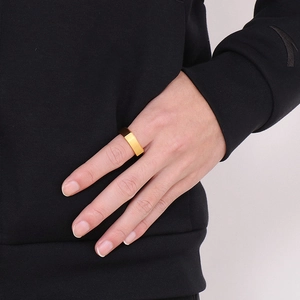 Close-up of a minimalist smooth gold square-shaped stainless steel ring worn on a finger
