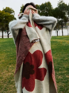 Close-up of thick knitted blanket with large floral patterns and visible loop texture