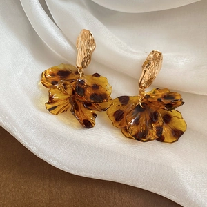 Macro detail of leopard print acrylic flower petals on vintage gold earrings