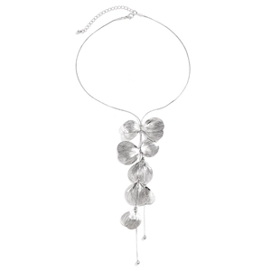 Detailed macro shot of silver ginkgo leaf pendants and long metallic chain tassels