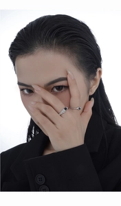 Detail of silver rings with wrinkled texture and black stone on a female hand