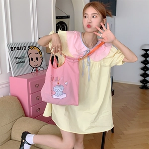Detailed view of the cute pink elephant embroidery on a yellow canvas tote bag