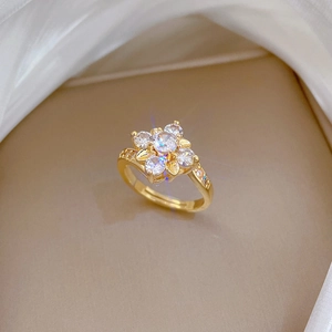 Adjustable gold flower ring with sparkling zircon petals on elegant beige velvet and silk